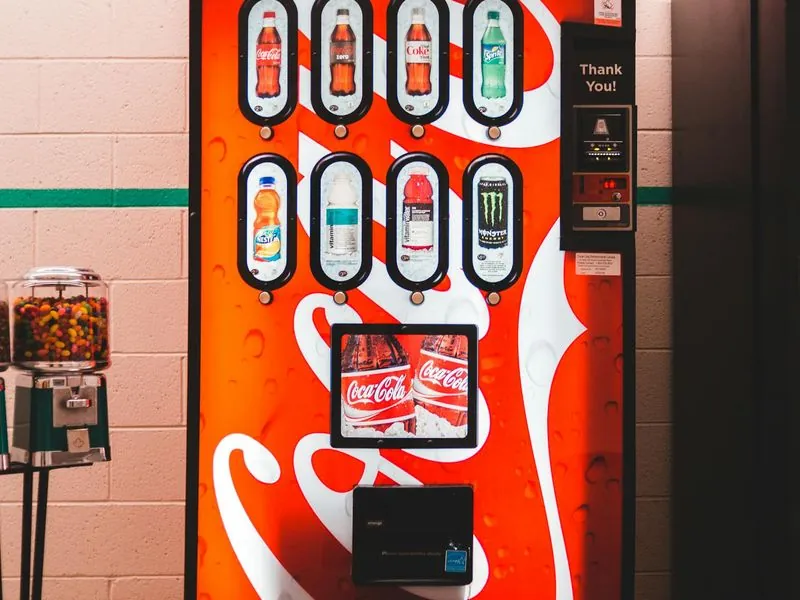 Vibrant indoor vending machine offering assorted sodas with eye-catching design.