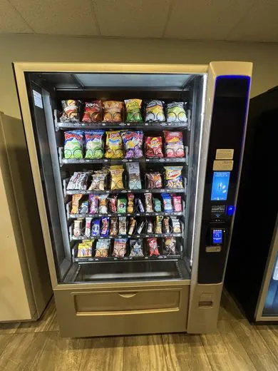 Touchscreen snack machine stocked with chips and bars