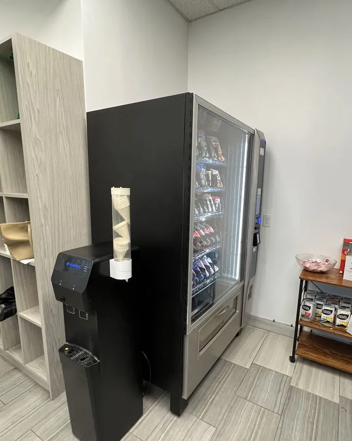 A man using the touchscreen on a modern snack vending machine